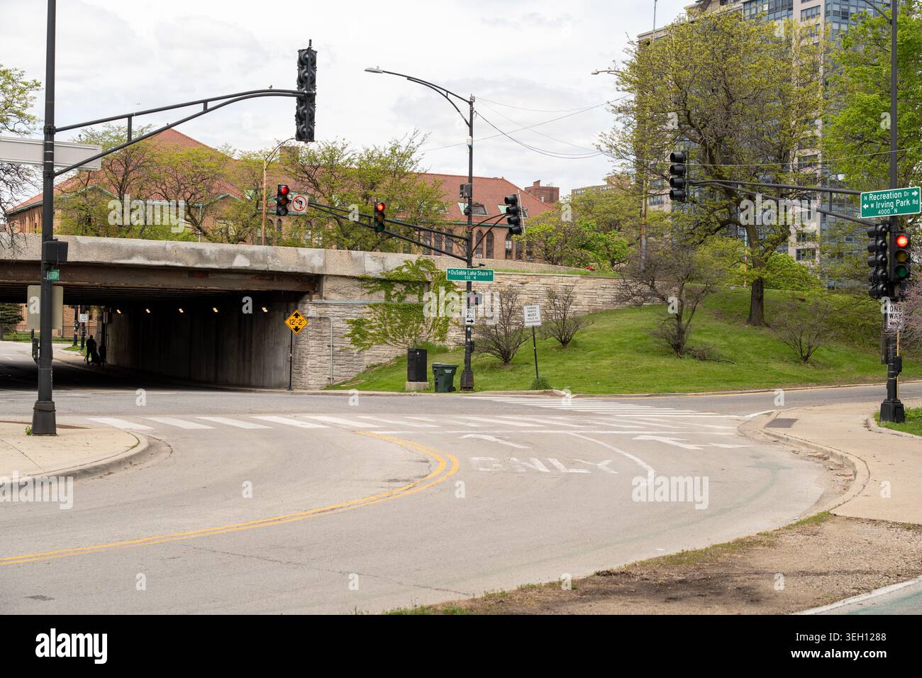 Vista orizzontale di una strada di Chicago con semafori, segnaletica stradale, frecce direzionali e ingresso di un tunnel urbano Foto Stock
