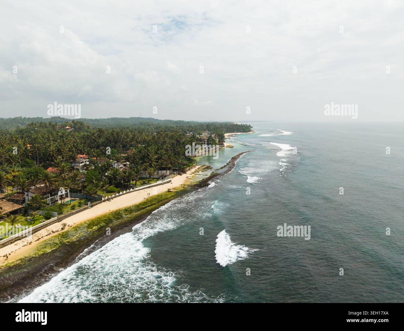 Vista aerea di Thalpe Beach con la spiaggia sabbiosa, le onde turchesi dell'oceano e le lussureggianti foreste di palme a Talpe, nella provincia meridionale dello Sri Lanka. Foto Stock