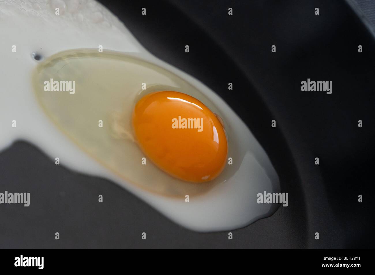 Processo di cottura delle uova. Primi momenti di frittura dell'albume. Osservare l'inizio delle uova friggere in padella. Illustrazione dettagliata della fase iniziale dell'uovo Foto Stock