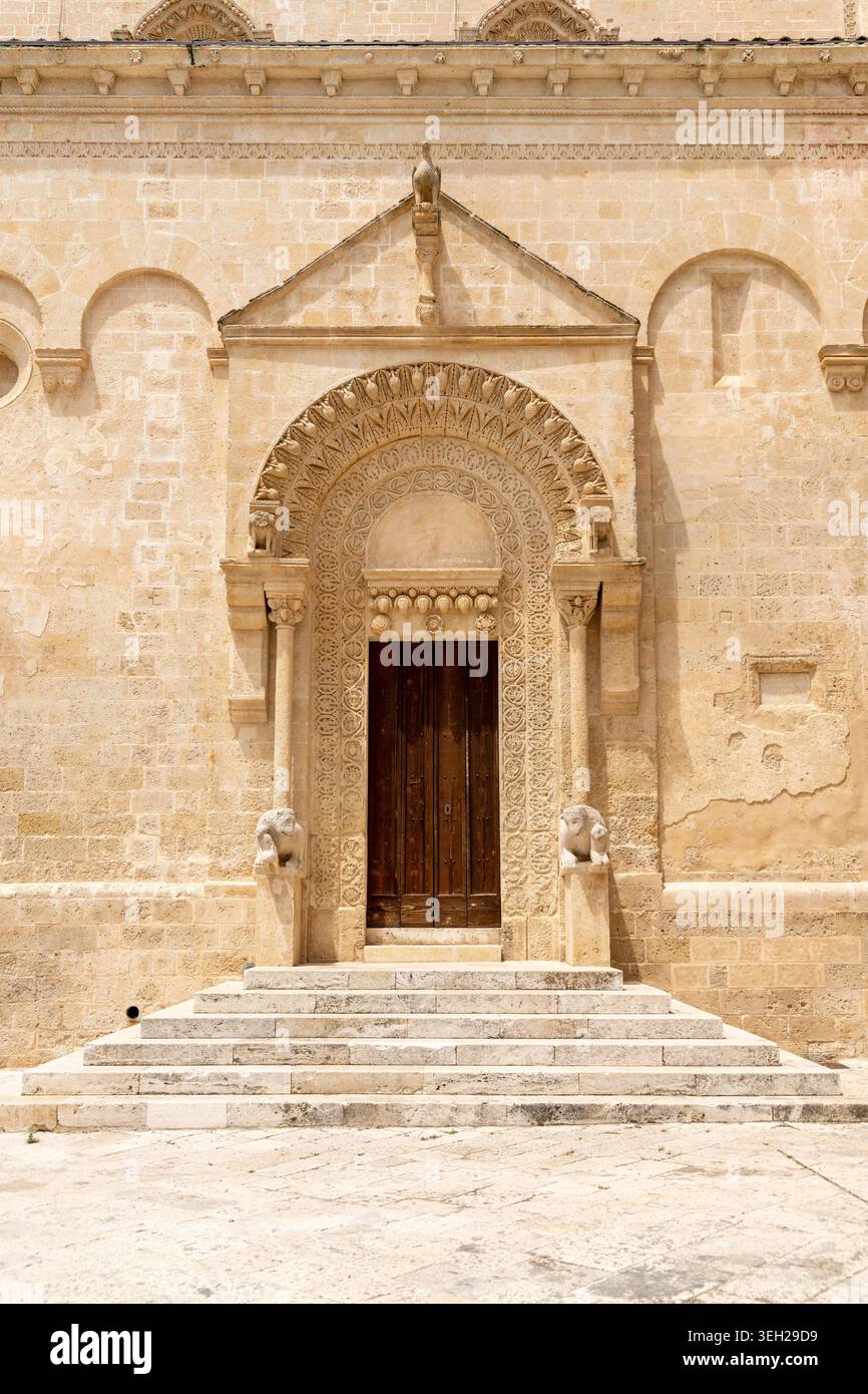 Porta della chiesa ornata ad arco a Matera, in Basilicata, con leoni in pietra, colonne scolpite, decorazioni semicircolari e ampi gradini frontali. Foto Stock