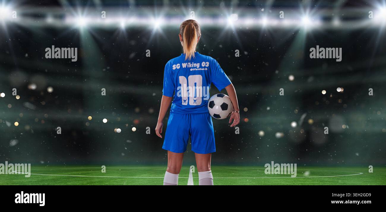 Ritratto di una giovane giocatrice di calcio con un pallone da calcio in piedi con una stella luminosa dietro Foto Stock