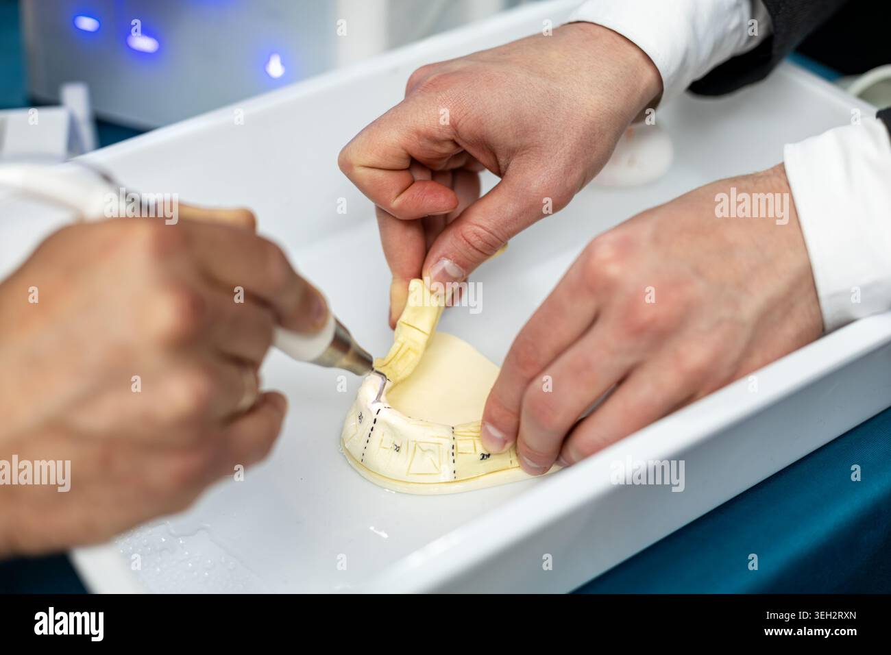 Esercitarsi con le mani sulla scalabilità dentale sul modello. Primo piano della formazione odontoiatrica con lo scaler a ultrasuoni che pulisce un modello di denti durante la formazione clinica pratica Foto Stock