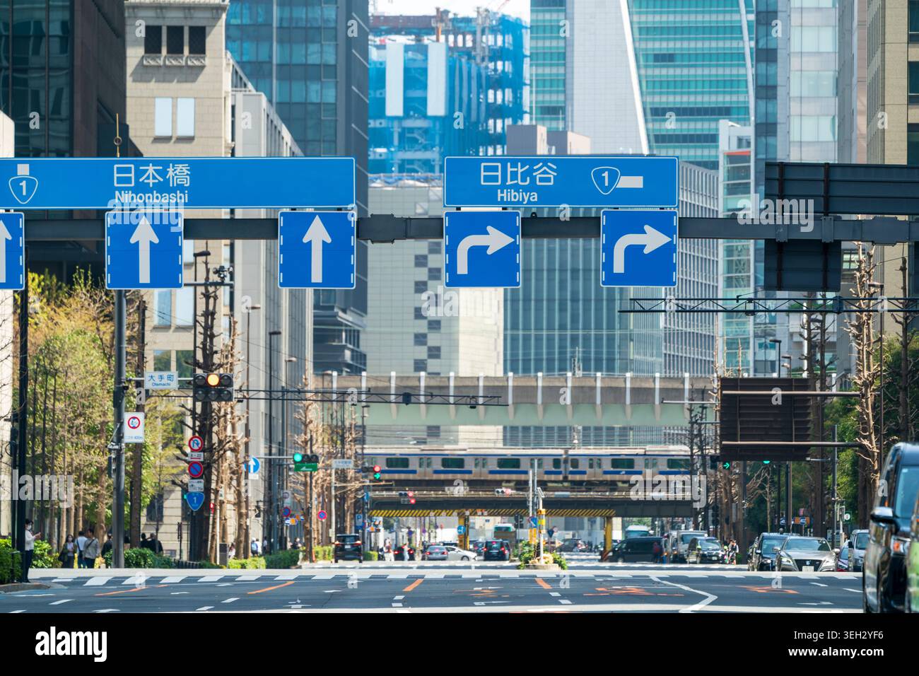 Ripresa in prospettiva compressa lungo Eitai-do dori avenue che porta alla stazione di Tokyo. Concentratevi sulle indicazioni stradali per Nihonbashi e Hibiya. Foto Stock