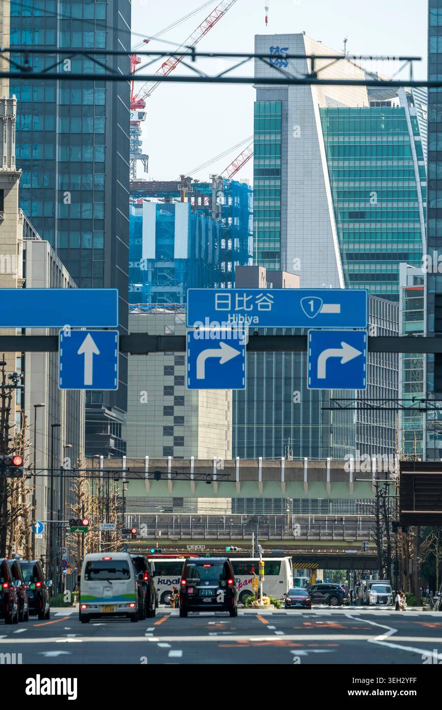 Ripresa in prospettiva compressa lungo Eitai-do dori avenue che porta alla stazione di Tokyo. Concentratevi sulle indicazioni stradali per Nihonbashi e Hibiya. Foto Stock