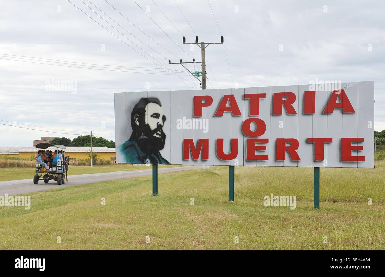 Cartello sulla strada da l'Avana, Cuba con scritto Patria o Muerte, patria o morte, il motto di Cuba. L'origine del motto deriva da un discorso del leader rivoluzionario Fidel Castro nel 1960. In un discorso del 1964 alle Nazioni Unite, che Guevara usò la frase iconica per comunicare la nuova posizione di Cuba contro le molestie dei governatori statunitensi Foto Stock