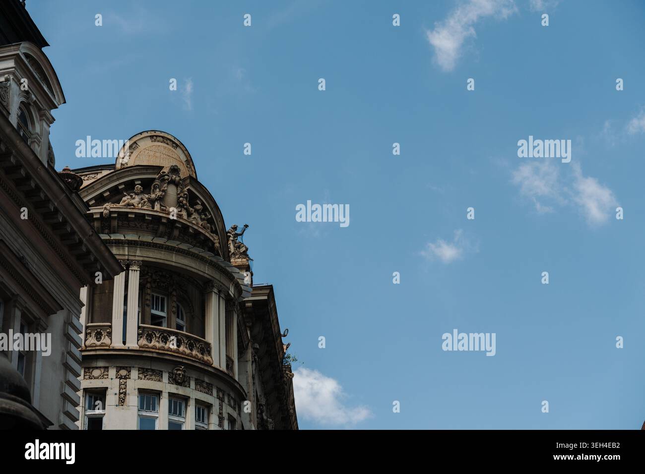 Facciata decorativa di un edificio storico si erge contro il cielo blu a Belgrado, Serbia. Concetto di patrimonio urbano, turismo, architettura e cultura europea. Foto Stock