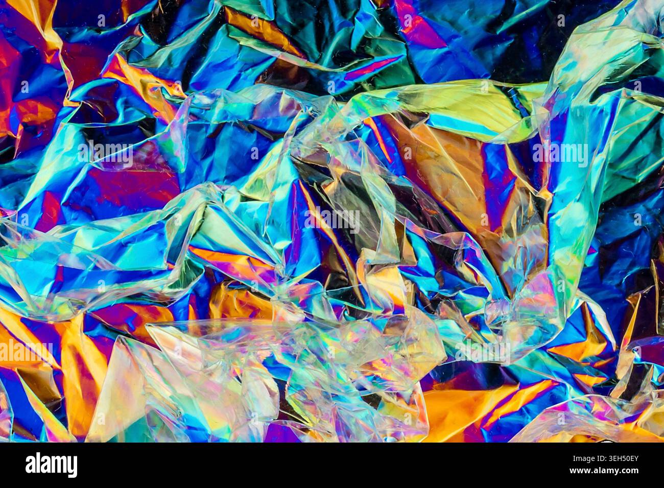 Il cellophane increspato sotto la luce polarizzata crea uno spettro astratto vivido, ideale per manifesti di eventi scientifici di grande impatto o per l'industria delle materie plastiche. Foto Stock