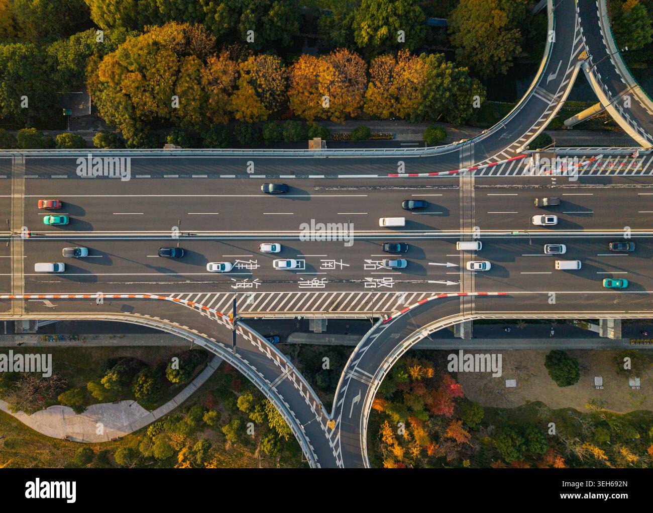 Moderno sistema autostradale con flusso di traffico attivo su più corsie, circondato da ricchi colori autunnali in Cina Foto Stock