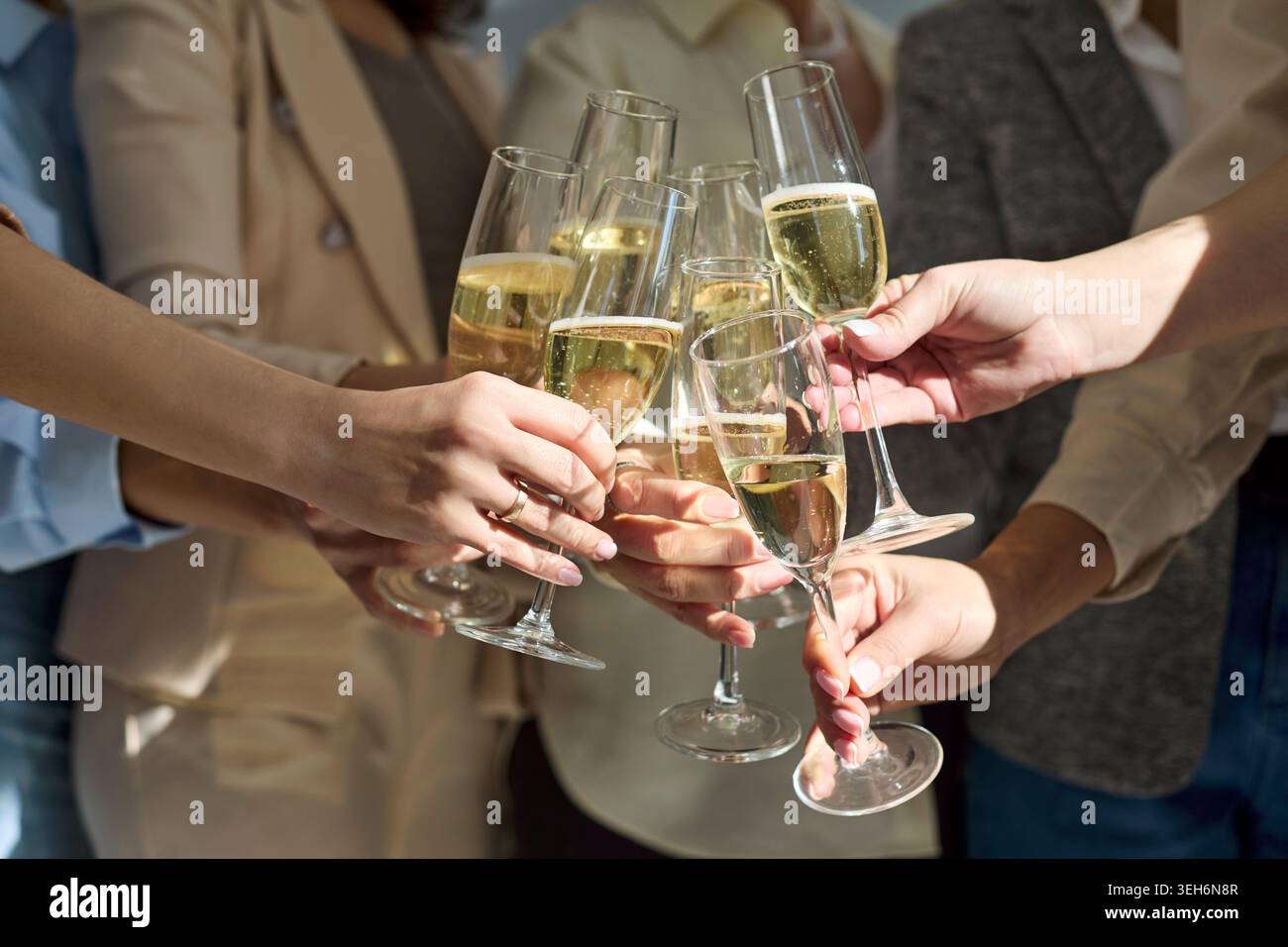 Gruppo che festeggia con flute di champagne, brindisi di successo al lavoro di squadra alla festa Foto Stock