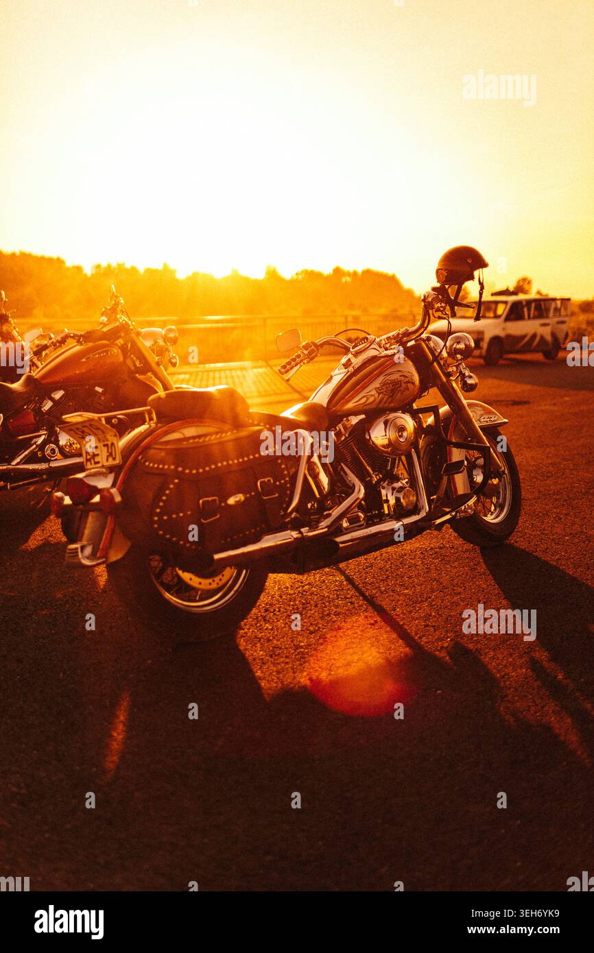 Motociclette classiche parcheggiate al tramonto con illuminazione dell'ora d'oro Foto Stock