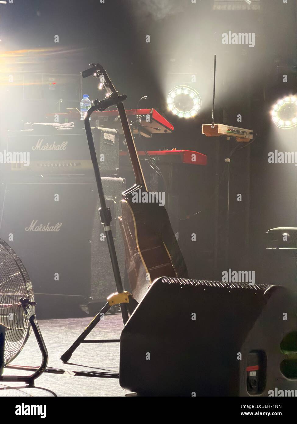 Palco musicale vuoto con chitarra acustica, tastiere e luci da concerto Foto Stock