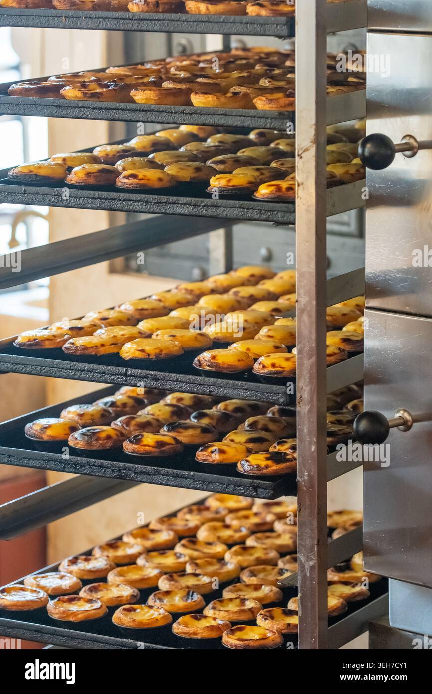 Crostate pastel de nata appena sfornate su rack di raffreddamento in forno Foto Stock