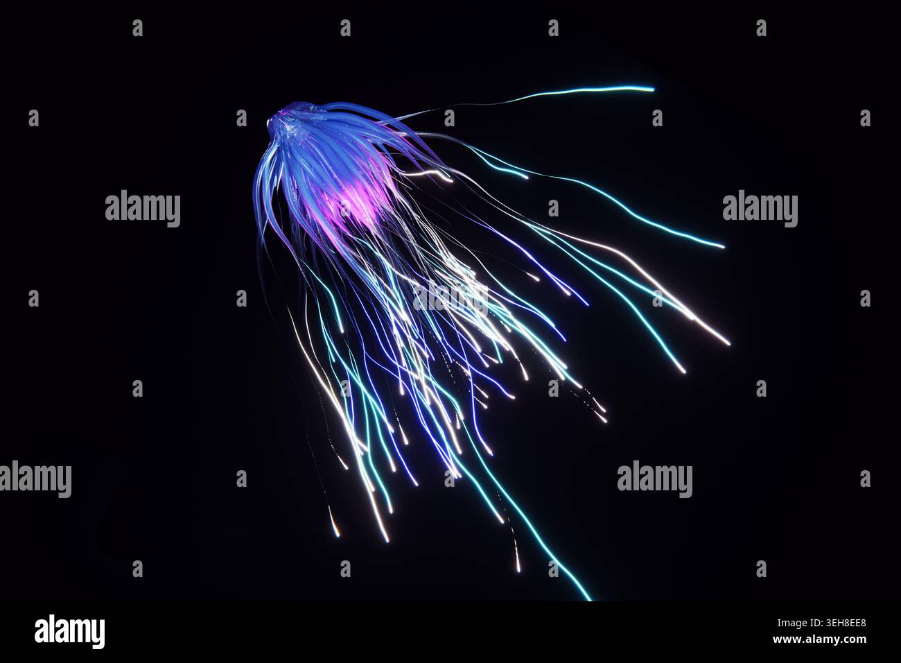 Creatura bioluminescente simile a meduse che galleggia in acque nere profonde. Futuristica illustrazione 3D di tentacoli azzurri al neon e viola, perfetta per Foto Stock