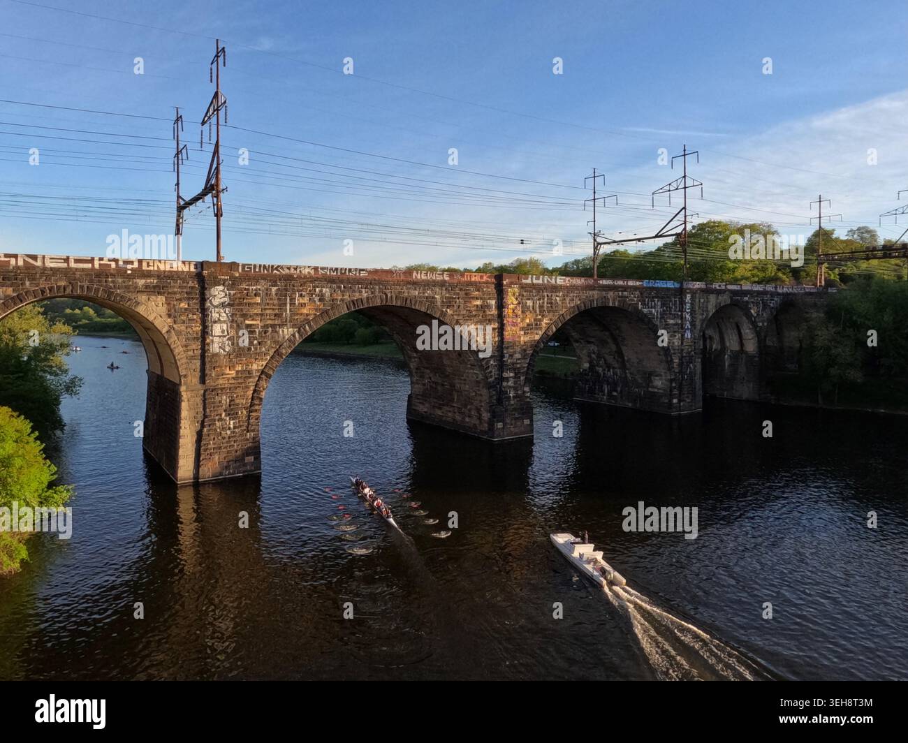 I canottieri si dirigono a nord attraverso gli archi della Pennsylvania Railroad, collegando Railway Bridge durante l'allenamento sul fiume Schuylkill a Philadelphia. Foto Stock