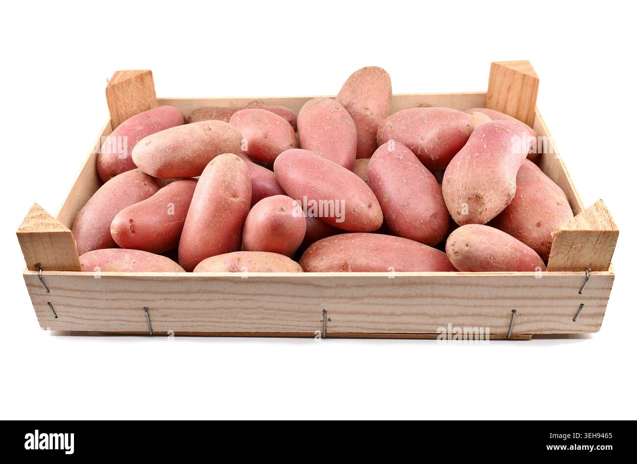 Cassa piena di patate rosse crude isolate su sfondo bianco. Foto Stock
