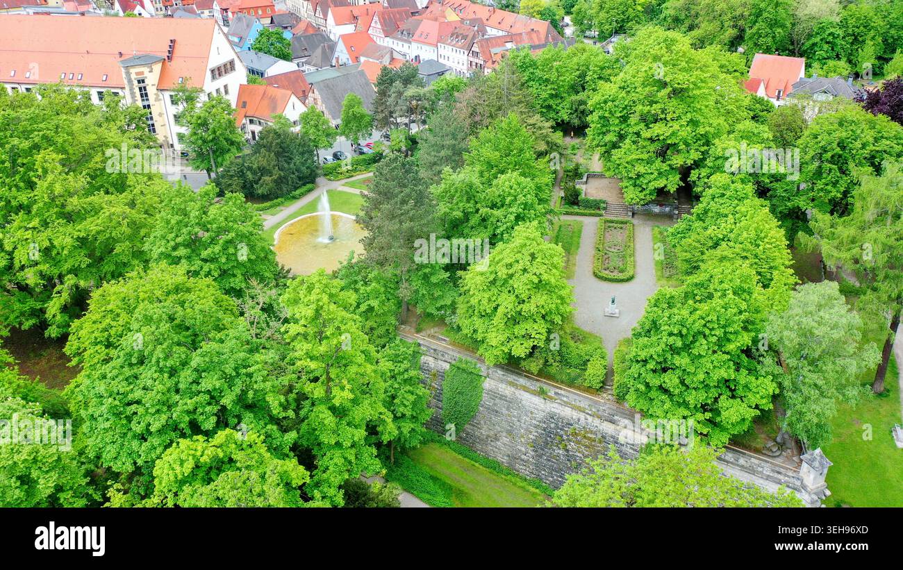 Vista aerea dello Stadtpark con lussureggianti alberi verdi, storici edifici dal tetto rosso e fortificazioni in pietra a Forchheim, Bayern, Germania. Foto Stock