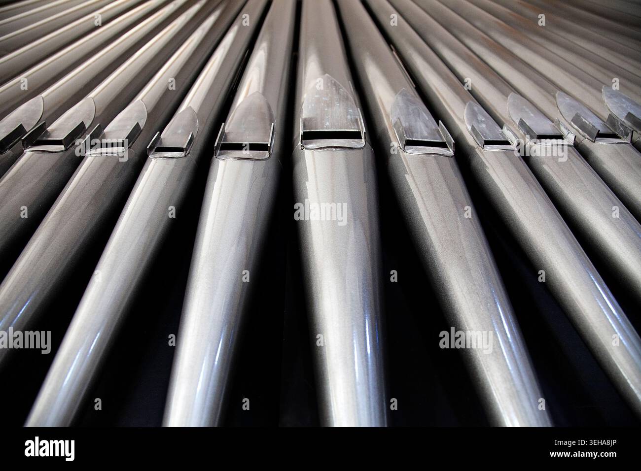 Le canne metalliche per organo della chiesa formano un sorprendente motivo astratto, creando uno sfondo musicale drammatico ideale per i manifesti di concerti e recital. Foto Stock