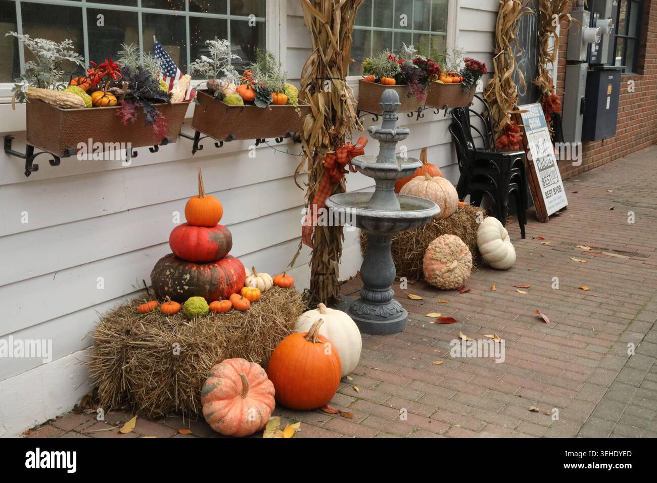 Mostra marciapiede a Clinton, New Jersey, con zucche, buongustai, balle di fieno, gambi di mais, fioriere, e una piccola fontana Foto Stock