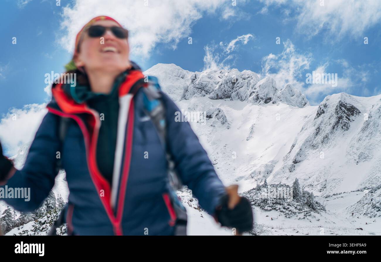 Maestoso monte Eisenerzer Reichenstein innevato in Austria con scalatore femminile sfocato in primo piano che rappresenta il fotograp alpino professionale Foto Stock