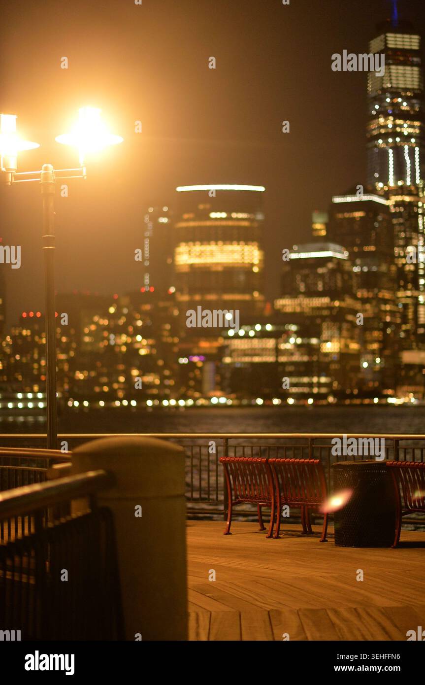 Le luci della città si illuminano. Lampioni e finestre alte illuminano la scena cittadina serale di New york Foto Stock