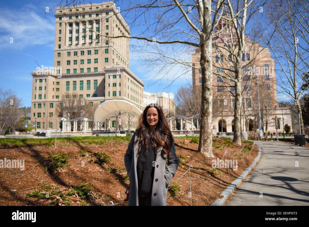Giovane donna che cammina vicino al tribunale della contea di Buncombe ad Asheville, North Carolina Foto Stock