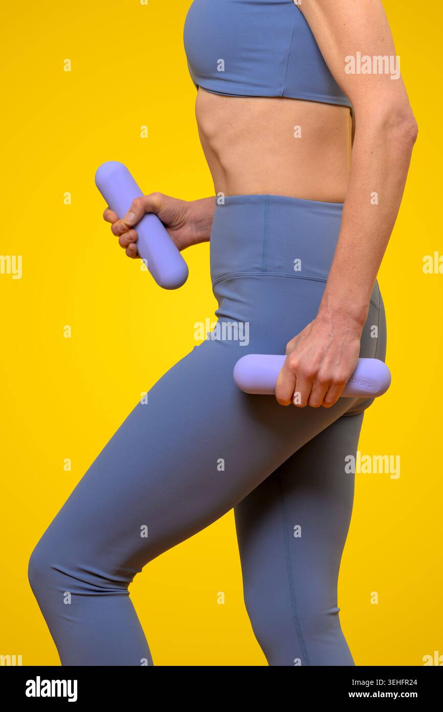 Donna in forma che lavora con Purple Dumbbells Foto Stock