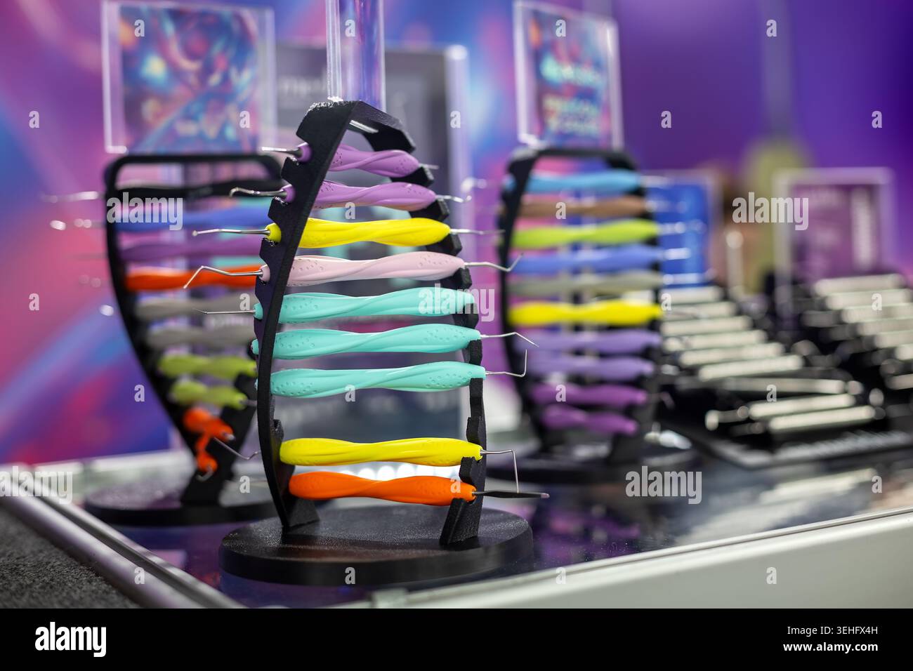 Strumenti dentali colorati visualizzati in clinica. Primo piano di strumenti odontoiatrici colorati disposti su banchi in una clinica moderna o in uno showroom di forniture odontoiatriche. Foto Stock
