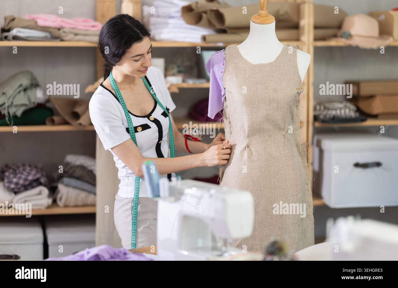 Sarta armena che lavora vicino al manichino in officina Foto Stock