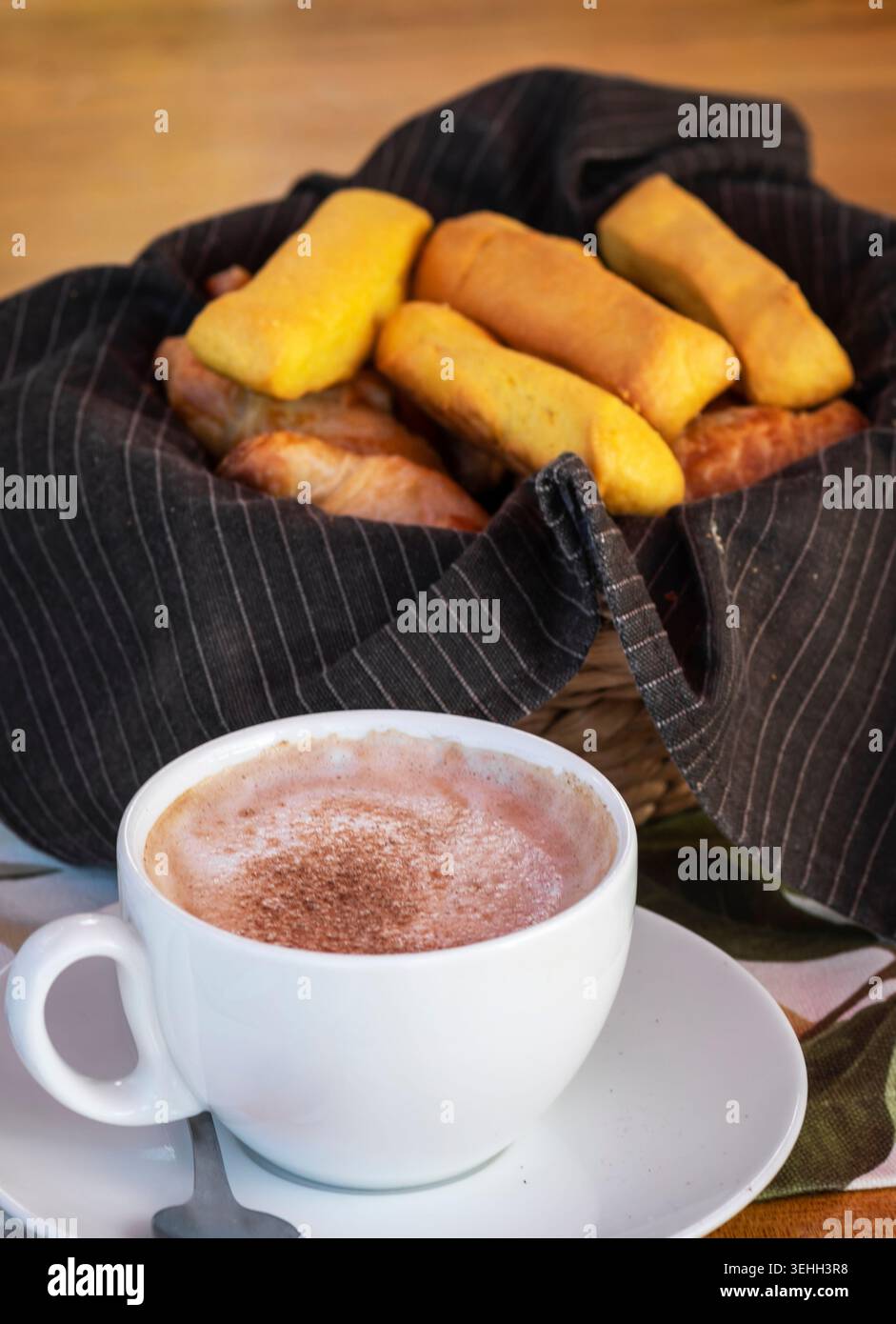 Biscottini ecuadoriani tradizionali con mini croissant e cioccolata calda in un ambiente accogliente per la colazione Foto Stock