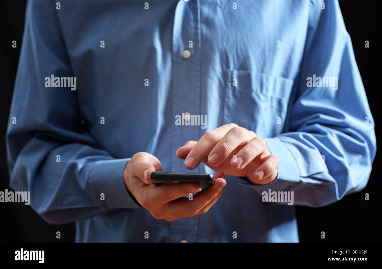 Mani di una persona che regge uno smartphone, tocca e scorre sullo schermo per la connessione digitale Foto Stock
