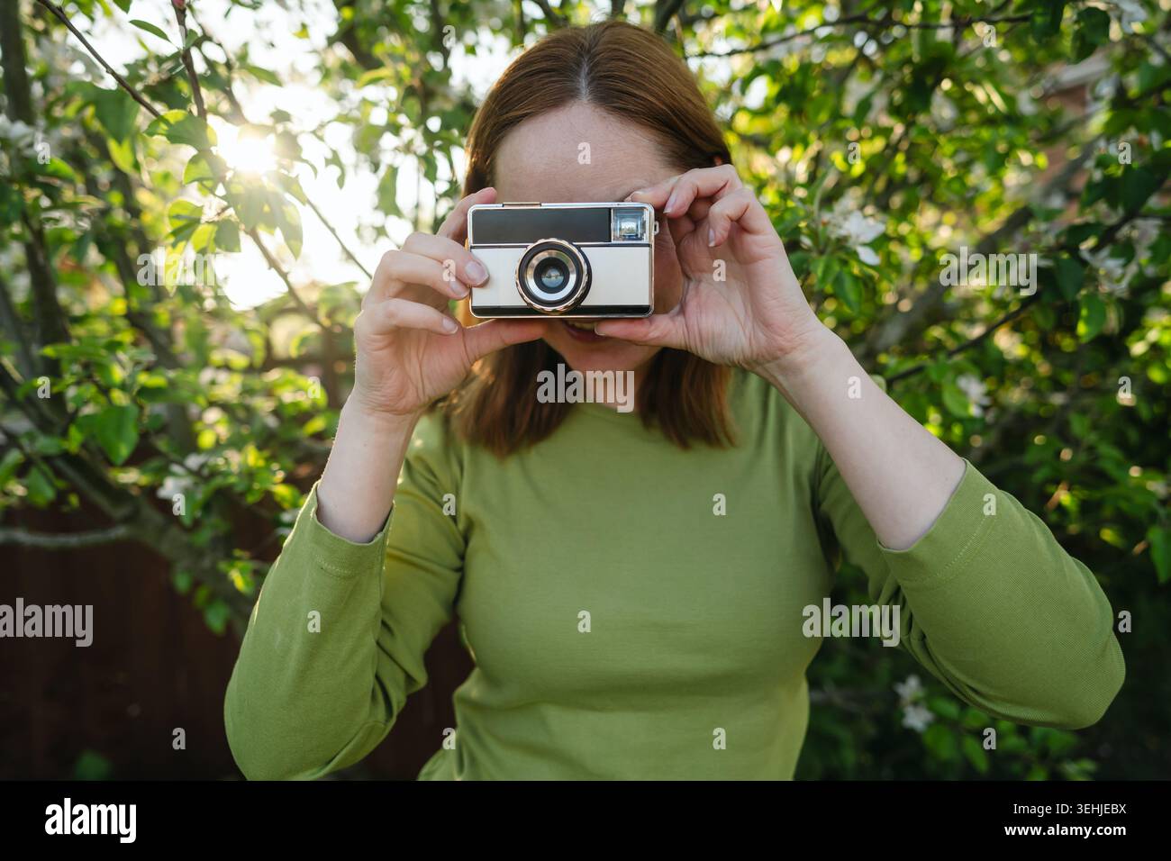 Primo piano di una fotocamera vintage tenuta da una donna all'aperto Foto Stock