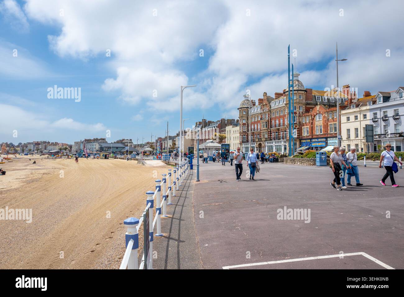 Visitatori e turisti che camminano lungo l'Esplanade, nella cittadina costiera meridionale di Weymouth, in una calda giornata di primavera di maggio. Foto Stock