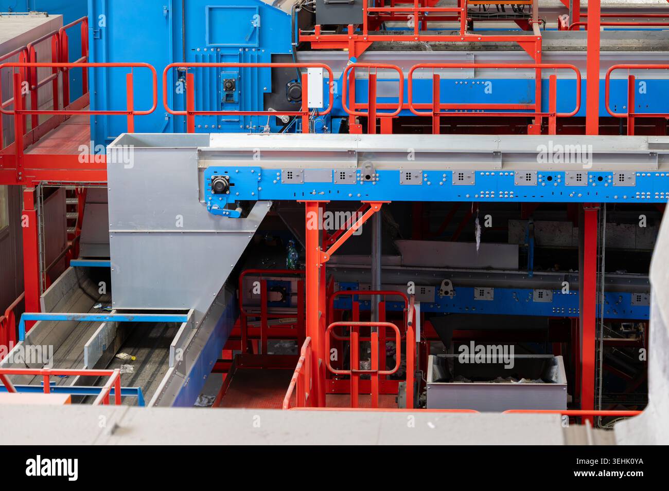 Linee di trasporto automatizzate e macchinari per lo smistamento dei materiali installati all'interno di un impianto di riciclaggio industriale. Strutture metalliche, nastri di trasporto Foto Stock