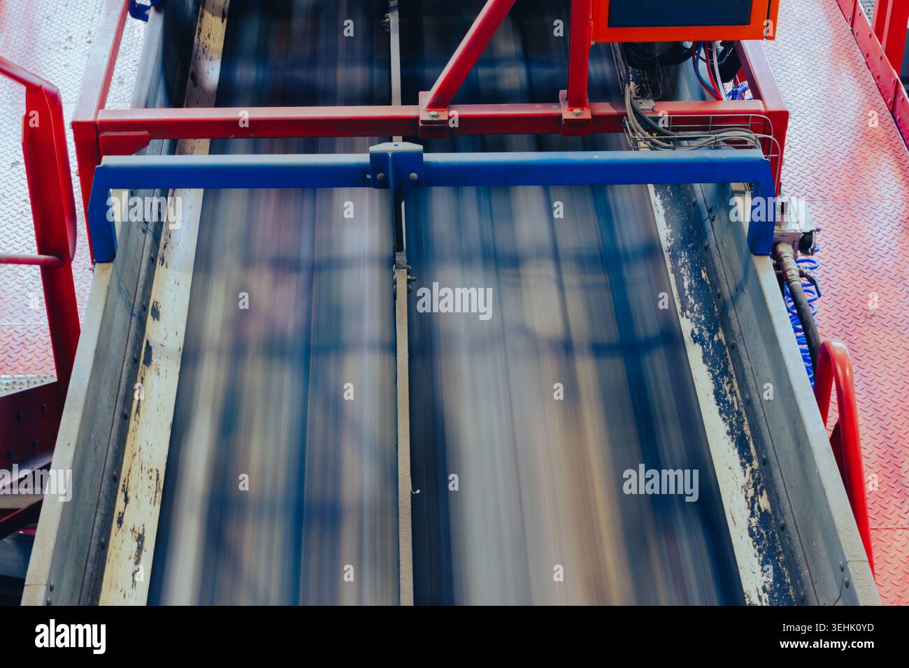 Sistema a doppio nastro trasportatore che opera all'interno di un impianto di riciclaggio industriale. Linee di trasporto automatizzate con sfocatura del movimento, strutture metalliche Foto Stock