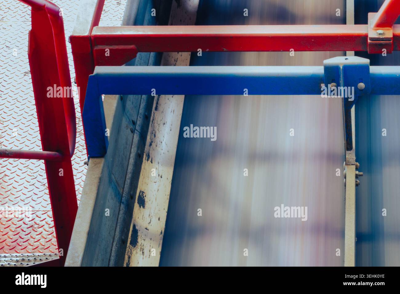 Nastro trasportatore di sfocatura del movimento all'interno di un impianto di riciclaggio industriale. Sistema di trasporto automatizzato con barriere metalliche e attrezzature di trattamento Foto Stock