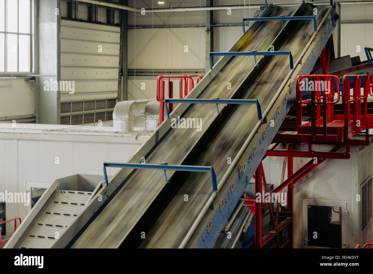 Nastro trasportatore ad alta velocità per il trasporto di materiali di scarto misti all'interno di un impianto di riciclaggio. Sistema automatizzato di smistamento ed elaborazione Foto Stock