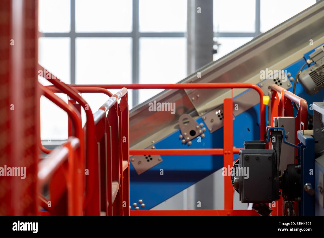 Sistema di trasporto industriale con ringhiere metalliche e attrezzature di lavorazione all'interno di un impianto di riciclaggio. Infrastruttura di trasporto automatizzata Foto Stock