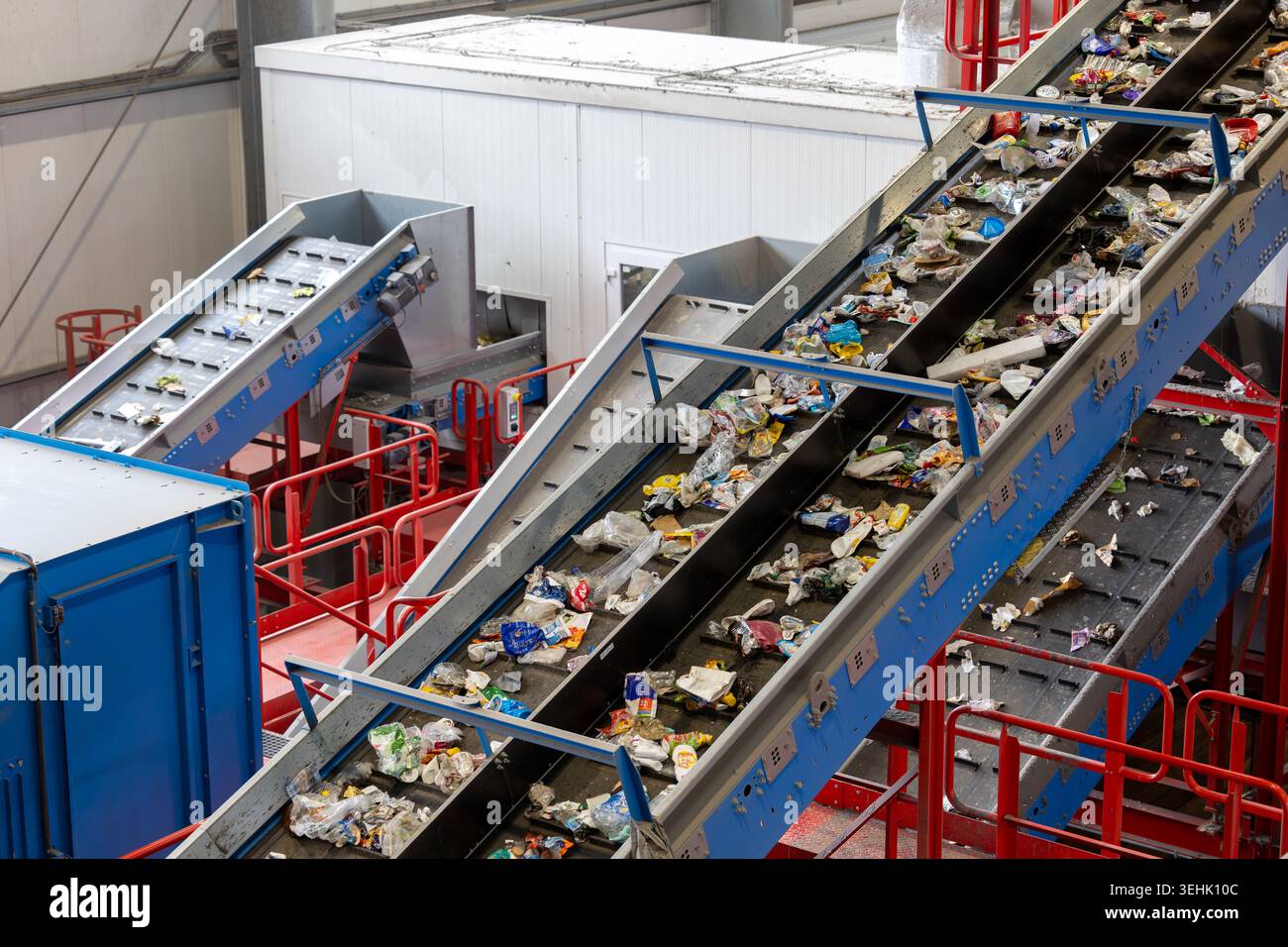 Sistema di nastri trasportatori che trasportano materiali di scarto misti all'interno di un impianto di riciclaggio. Linee di smistamento industriali con rifiuti di plastica, trattamento automatizzato Foto Stock
