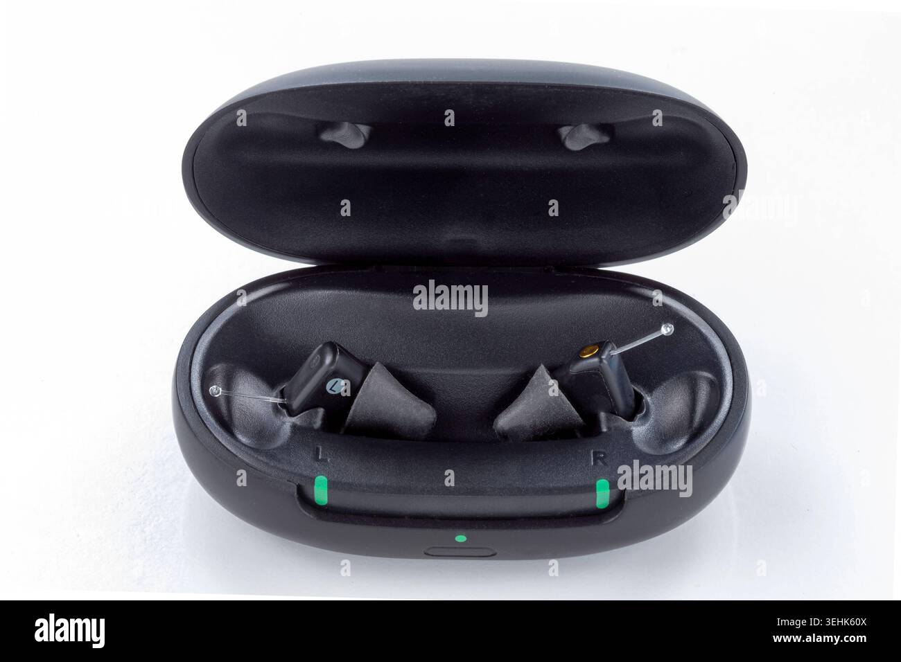 Due auricolari wireless neri si trovano all'interno di una custodia di ricarica nera aperta su uno sfondo bianco. Sul caso sono visibili tre luci verdi. Auricolari wireless. Bsip_016938_145 Foto Stock