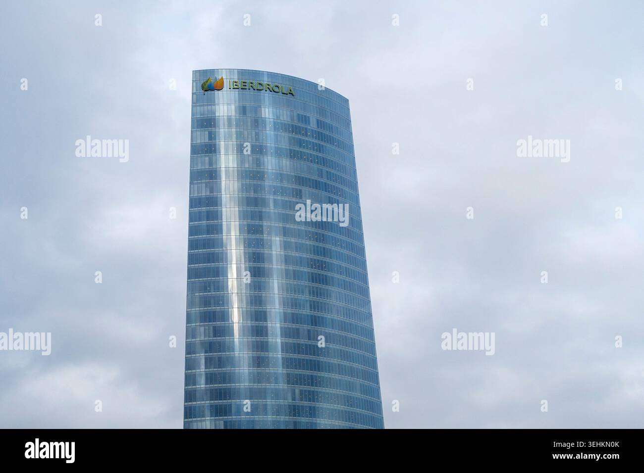 La moderna facciata in vetro del grattacielo Iberdrola Tower contro un cielo nuvoloso a Bilbao, Spagna Foto Stock