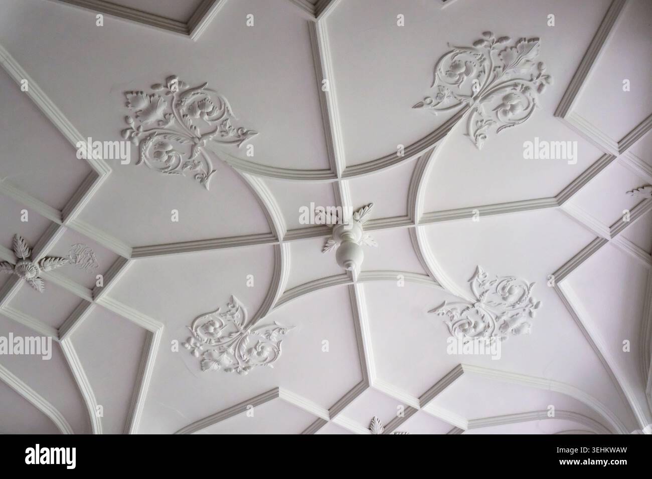 Soffitto decorativo in cartongesso in stile giacobino con nervature da lavoro a nastro, motivi floreali e pendente centrale. Foto Stock