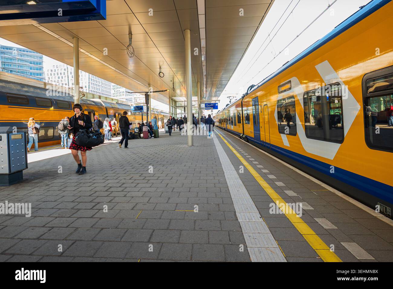 Amsterdam, Paesi Bassi, 22.04.2026 - passeggeri che camminano vicino ai treni NS gialli al binario della stazione ferroviaria dei Paesi Bassi Foto Stock