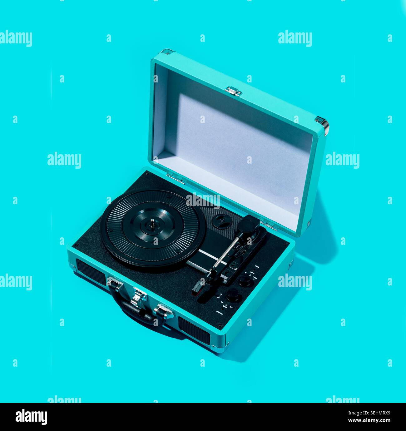 Lettore di dischi vintage aperto su sfondo blu brillante, allestimento minimale in studio con vassoio in vinile e tonearm, che evocano l'ascolto di musica retrò, n Foto Stock