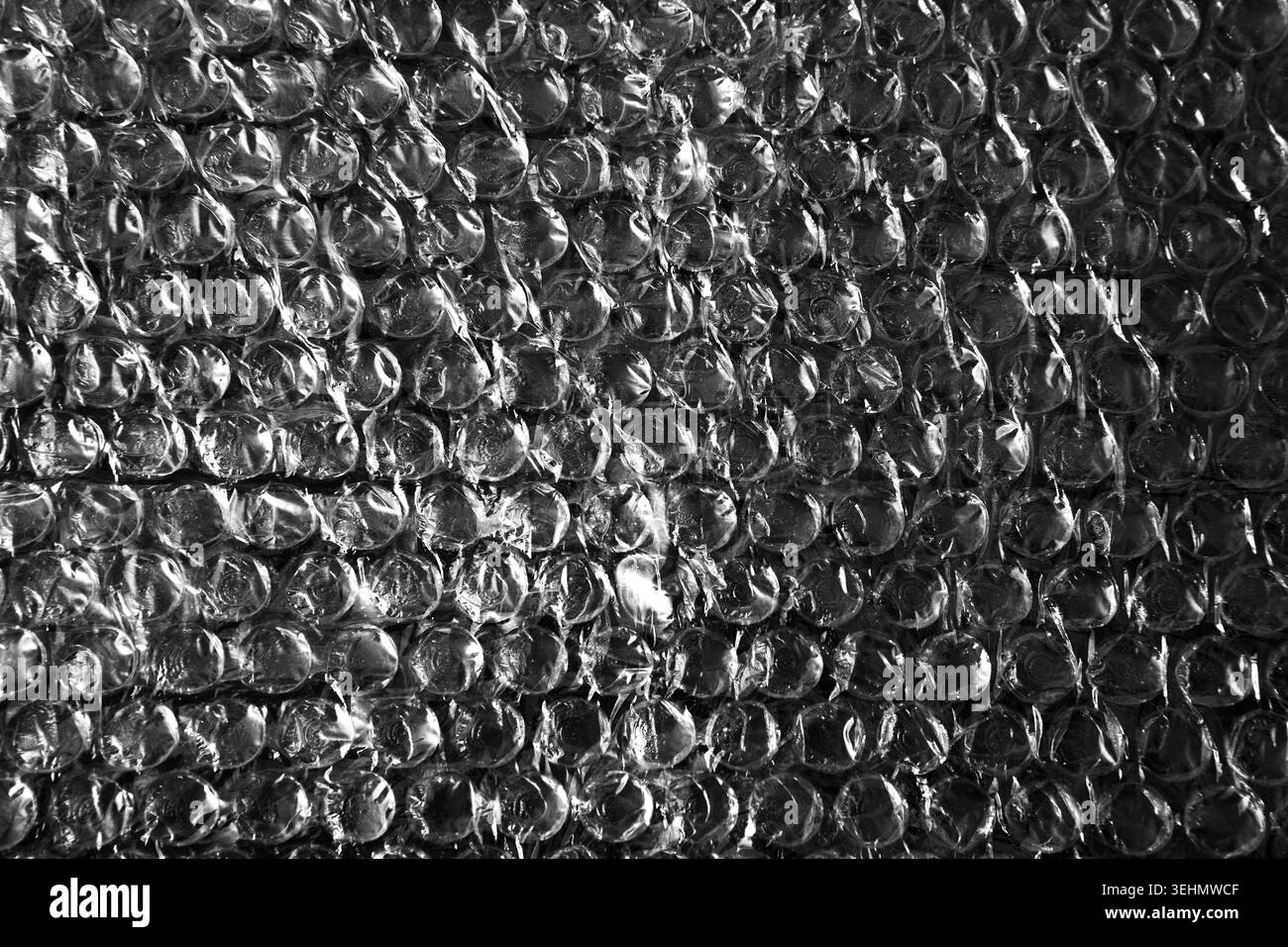 Primo piano di confezioni trasparenti di bolle d'aria in plastica, che formano una trama protettiva lucida. Sfondo del materiale di imballaggio per la spedizione, cushi Foto Stock