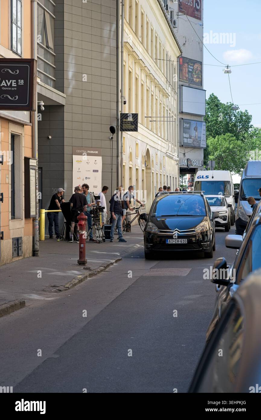 Budapest, Ungheria - 22 maggio 2026: Una troupe professionale con attrezzature cinematografiche lavora sul marciapiede di via Paulay Ede fuori dal passaggio centrale Foto Stock