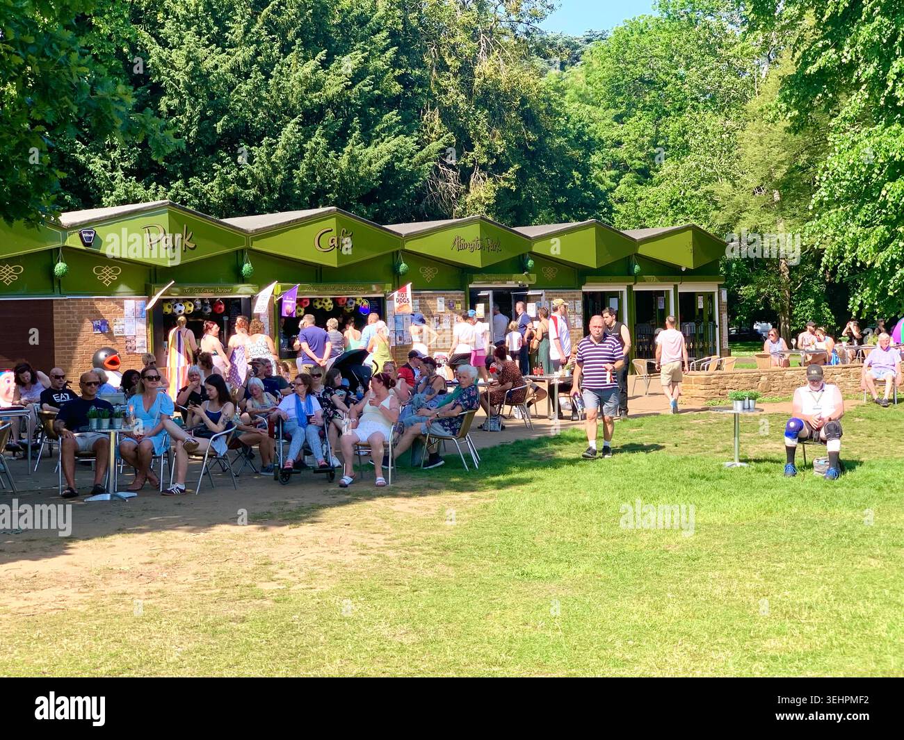 L'artista tributo a Elvis intrattiene la folla all'Abington Park Northampton, Inghilterra, cantando in estate con la folla che guarda vicino alla tribuna - Immagine stock catturata con smartphone