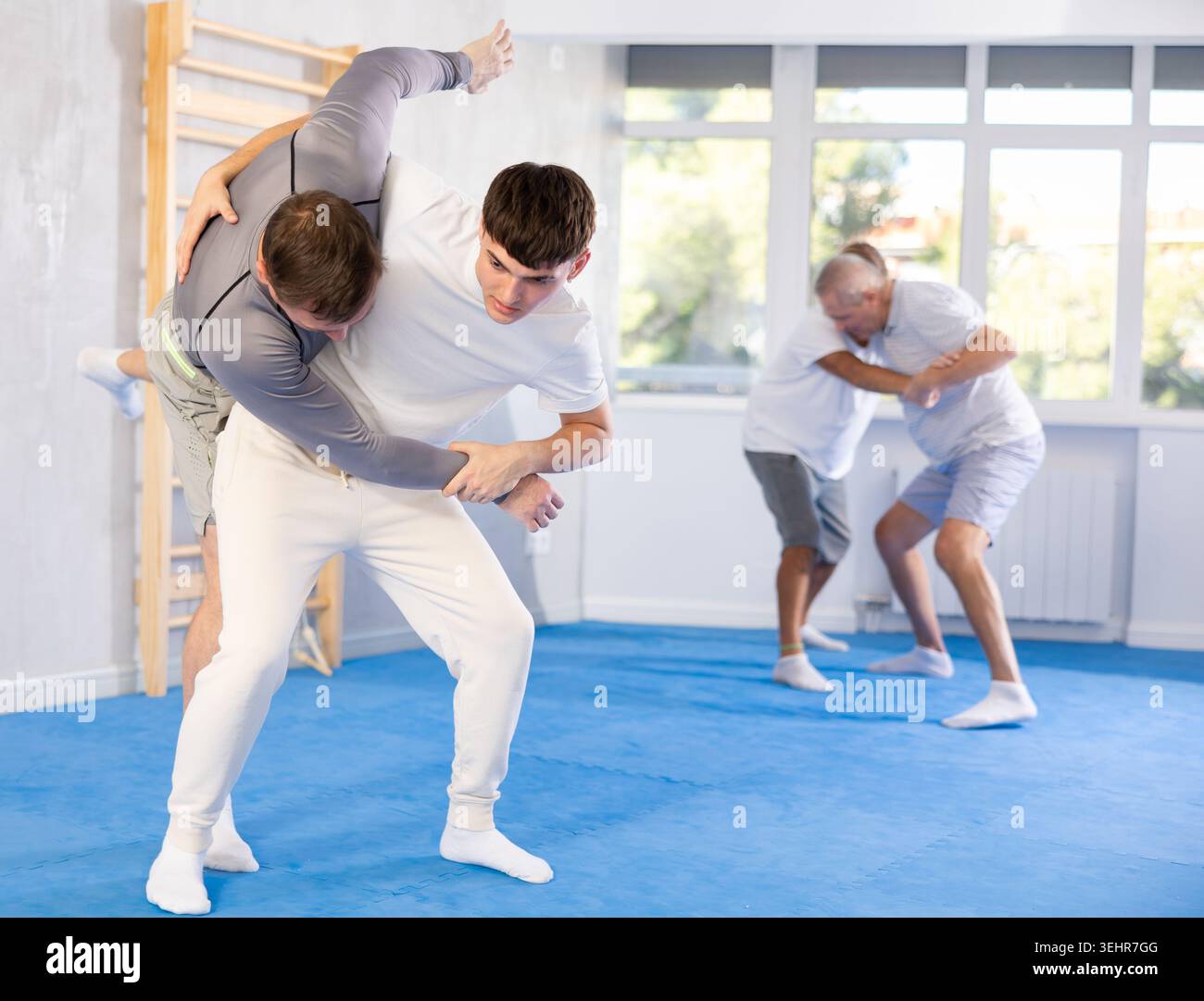 Giovani e uomini esercitano il wrestling, applicano tecniche di Aikido e autodifesa. Foto Stock