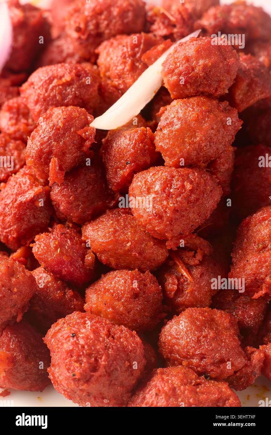 primo piano di pezzi di soia rossa piccante cotti a tutto tondo, sfondo sostitutivo della carne proteica vegetariana Foto Stock