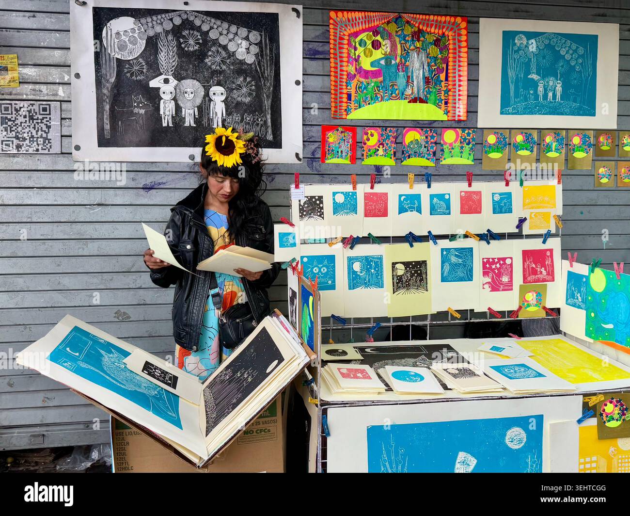 Un artista espone stampe colorate e illustrazioni fatte a mano in uno stand d'arte all'aperto a Coyoacán, città del Messico, Messico. Foto Stock