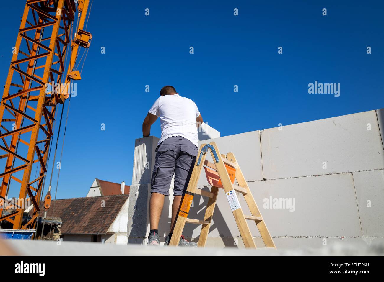 Il muratore lavora su una nuova casa indipendente Foto Stock